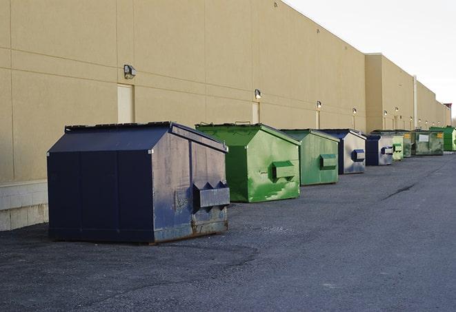 a fleet of red and blue construction dumpsters available for use in Cedar Bluffs